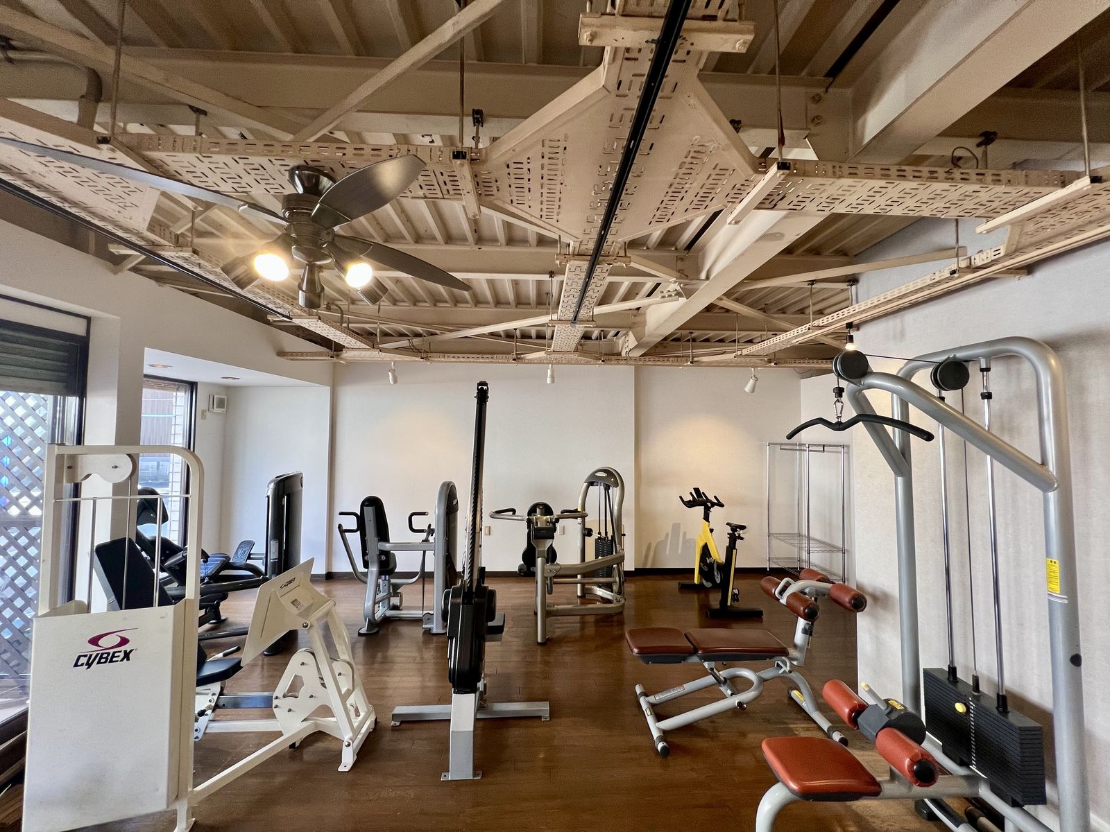 館内の全景。木の床とシーリングファンのある空間に、トレーニングマシンが並んでいる